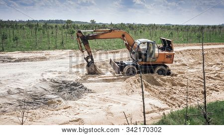 The Excavator Works On The Consruction Of The Road Through The Swamp.