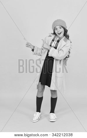 Look At Closely. Surprised Child In Autumn Fashion Pointing At Something. Small Schoolgirl With Open