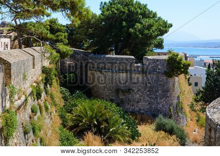 Part Of The Wall And The Tower Of The Fortress Of Fortezza With Loopholes. Overgrown With Palm Trees