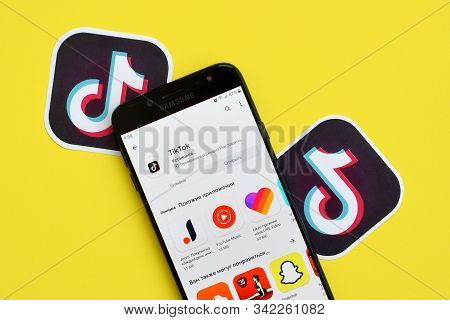 Tiktok Application In Playmarket On Samsung Smartphone Screen On Yellow Background. Tiktok Is A Popu