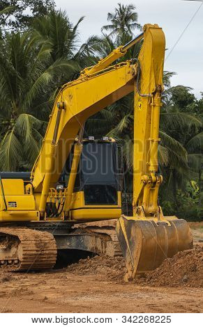 Yellow Excavator On A Construction Site Against Blue Sky. Heavy Industry. Close Up Details Of Indust