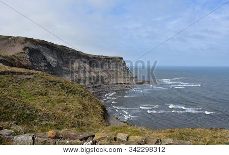 Stunning View Of Robin Hood's Bay With Waves Rolling Ashore