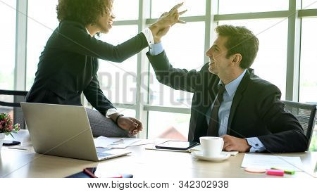 Hispanic And African Interracial Colleague High Five Congratulate Work