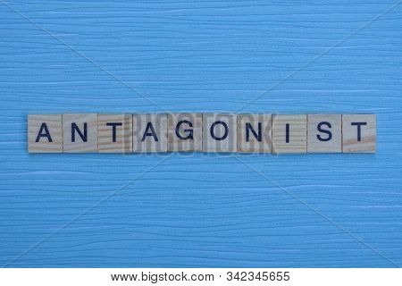 Gray Word Antagonist From Small Wooden Letters On A Blue Table