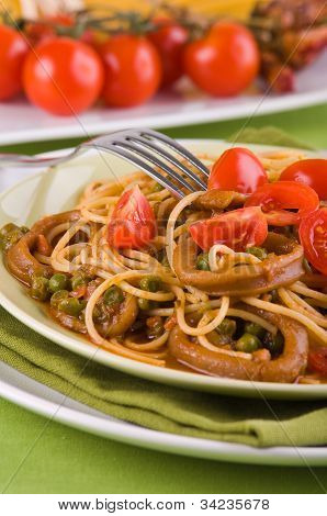 Spaghetti with squids peas and cherry tomatoes.