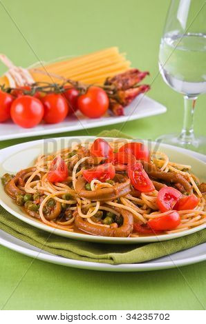 Spaghetti with squids peas and cherry tomatoes.