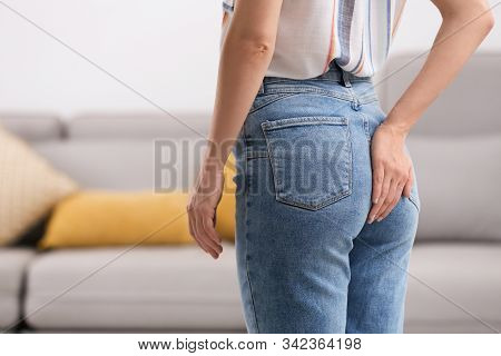 Young Woman Suffering From Hemorrhoid At Home, Closeup