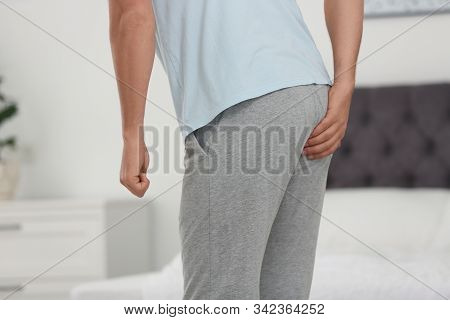 Man Suffering From Hemorrhoid In Bedroom, Closeup