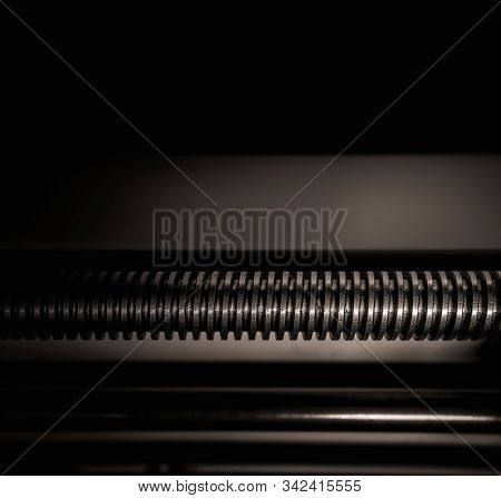 Lathe Part - A Feeder Rod With A Thread On A Dark Background. Close Up. Black Whiote. Space For Text