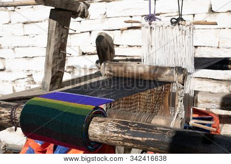 A Loom Setting Outdoors With Some Very Colorful Cloth In It.