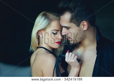 Sexy Dominant Blonde Woman With Macho Man Lover Holding Whip, Sex Toy, Bdsm, Indoors