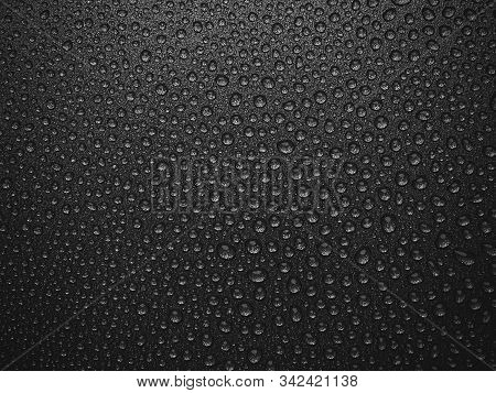 Abstract Background: Many Drops Of Water On A Dark Surface - Non-stick Coating In A Pan. Black And W