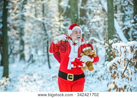 Santa Magical Fog Walking Along The Field. Santa Claus With A Huge Bag. Wish You Merry Christmas. Sa