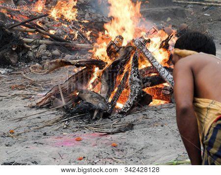 Puri,odisha/india-march 12 2018:a Worker Tends The Pyre Of A Hindu Person At Swargadwar Crematorium 