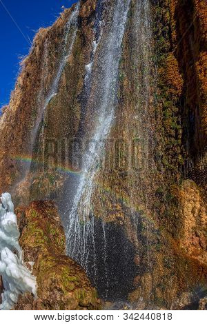 Rainbow In A Waterfall Above The Entrance To The Karst Cave.