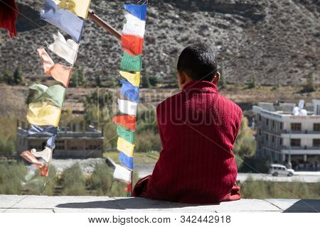 Young Novice Monk Sitting Outside Buddhist Temple