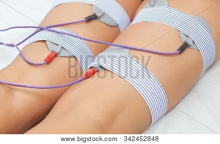 The Procedure Of Myostimulation On The Legs And Buttocks Of A Woman In A Beauty Salon. Overweight Tr