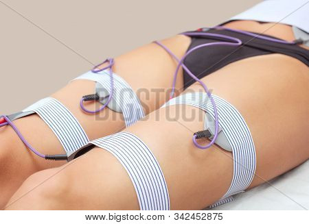The Procedure Of Myostimulation On The Legs And Buttocks Of A Woman In A Beauty Salon. Overweight Tr
