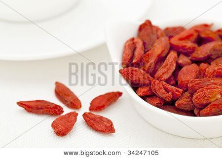 bagas de goji secas orgânicas (wolfberry) em uma tigela de cerâmica pequena - superalimento tibetano