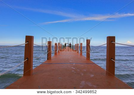 Perspective View Of A Cement Pier On The Seashore With Clear Blue Sea At Sawangan Beach,kuala Penyu,