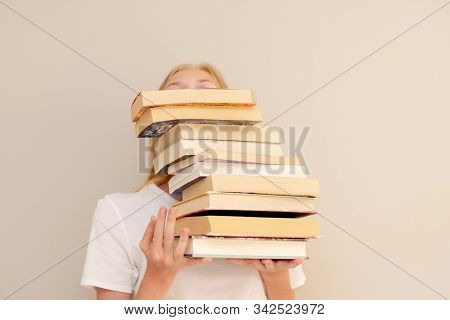 Teenage Girl Hiding Behind Big Pile Of Books She Wants To Read. Student Ready To Study Concept