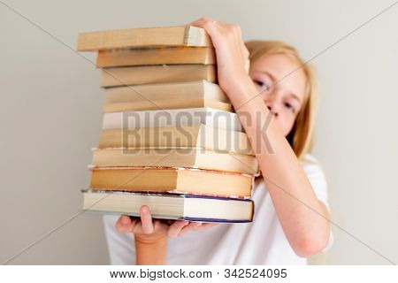 Teenage Girl Hiding Behind Big Pile Of Books She Wants To Read. Student Ready To Study Concept