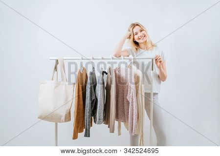Clothing, Fashion, Style And People Concept - Woman Choosing Clothes At Home Wardrobe On White Backg