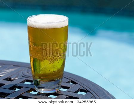 Glas Bier am Tisch am Pool