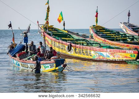 Tanji, The Gambia - November 21, 2019: Scene With Men And Women Carrying Fish From The Boats To The