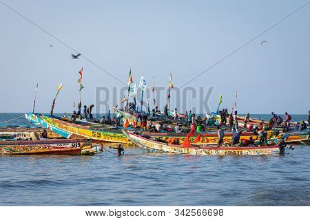 Tanji, The Gambia - November 21, 2019: Scene With Men And Women Carrying Fish From The Boats To The