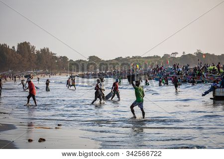 Tanji, The Gambia - November 21, 2019: Scene With Men And Women Carrying Fish From The Boats To The