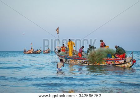 Tanji, The Gambia - November 21, 2019: Scene With Men And Women Carrying Fish From The Boats To The
