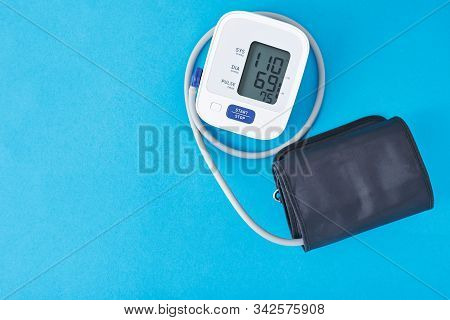 Digital Blood Pressure Monitor On A Blue Background, Closeup. Helathcare And Medical Concept