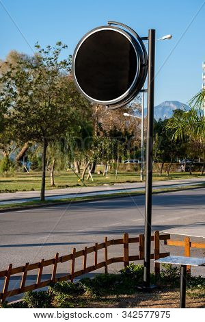 Round Black Signboard On The Street In The City