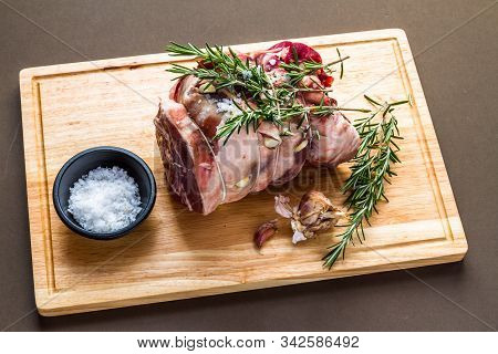 Raw Rolled And Tied Herdwick Sheep Lamb Joint Prepared With Garlic, Rosemary And Sea Salt.