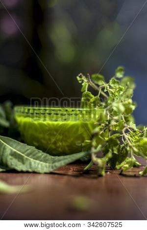 Close Up Shot Of Glass Bowl Full Of Tulsi Or Basil And Neem Or Indian Lilac Paste In It Along With F