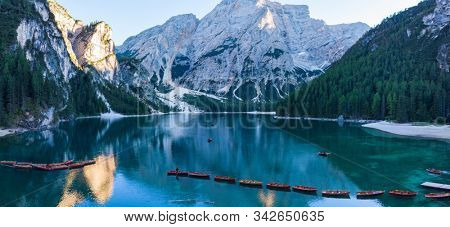 Braies Lake in Dolomites mountains forest trail in background, Sudtirol, Italy. Lake Braies is also known as Lago di Braies. The lake is surrounded by forest which are famous for scenic hiking trails.