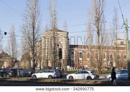 Milan, Italy - January 01, 2020: Exterior Of Cimitero Monumentale Of Milano In Milan; Cars Passing B
