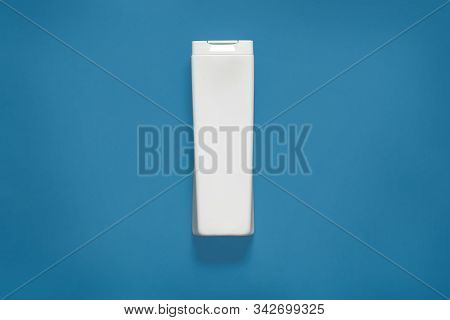 Minimal Style. Classic Blue Color Of The Year 2020. White Plastic Bottle Isolated Over Phantom Blue 