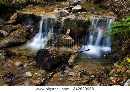 Small Waterfall From A Creek In A Forest In The Alps