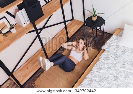 Attrctive Fitness Woman Doing Stretching Exercises At Home, As Part Of A Healthy Lifestyle Without G