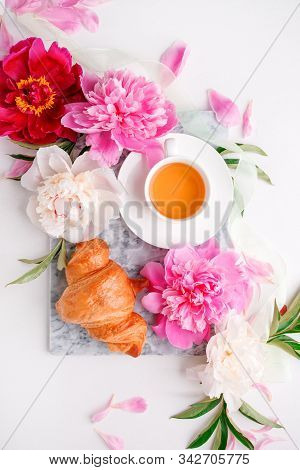 Breakfast For Valentines Day With Cup Of Tea, Peony Flowers And Croissant On Gray Murble Table And W