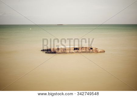 Ruins of harbor built by the Allies in Arromanches, Normandy, France.