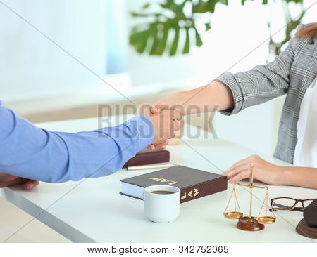 Female Lawyer And Man Shaking Hands In Office