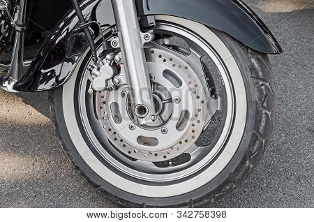 Front Wheel Of Chopper Motorcycle. Close-up Depicts Wheel Mount And Motorcycle Brake System