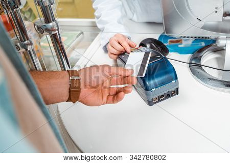 Cropped View Of Customer Paying With Paypass In Pharmacy