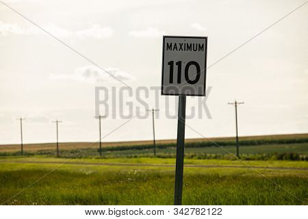 Selective Focus View Of 110 Maximum Speed Limit Sign On The Roadside, Against Prairies And Plains Vi