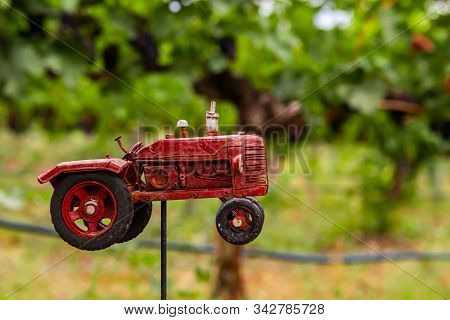 Handmade Red Tractor Metal Old Toy Selective Focus With Against Vineyard Vine Grapes Field Blurred B