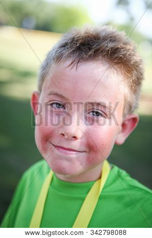 Closeup of a hot and smiling boy at the finish of a marathon or triathlon 