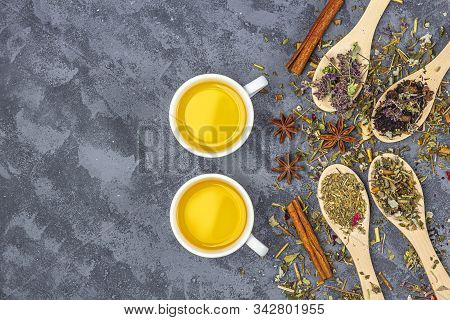 Assortment Of Different Grade Dry Tealeaf In Wooden Spoons And Two Cup Of Green Tea. Organic Herbal,